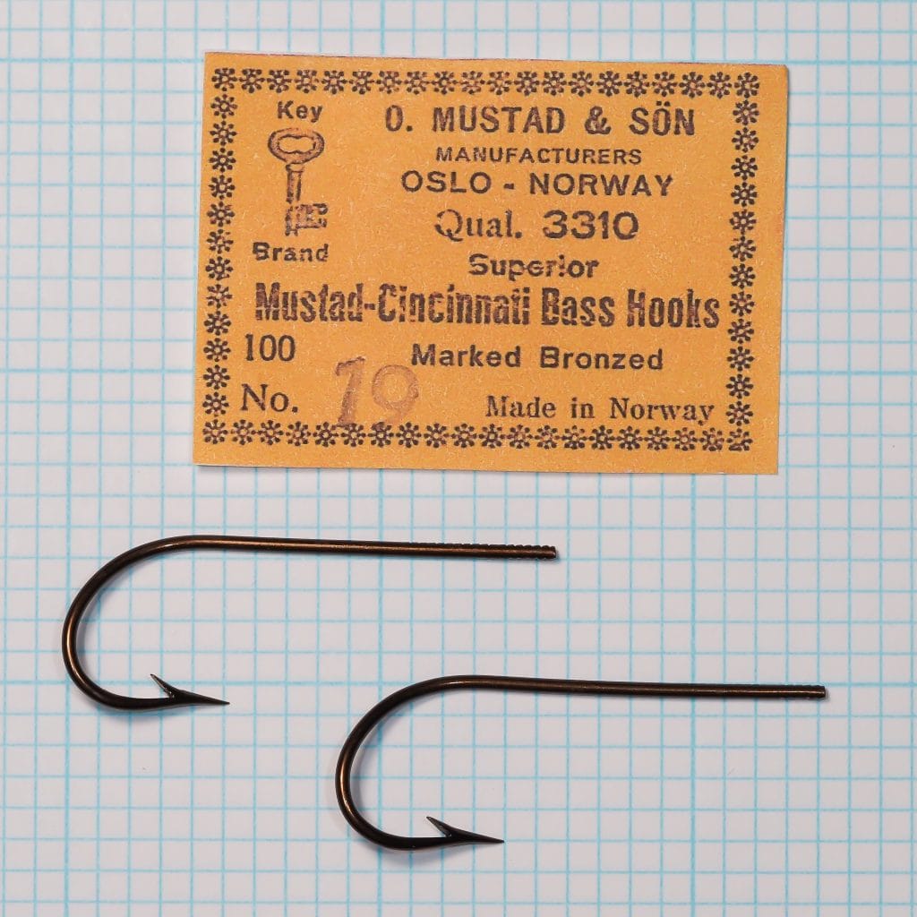Mustad Quality 3310 printed Cincinnati Bass Hooks card or label with Key Brand device, handwritten size 19, and two loose bronzed hooks below.