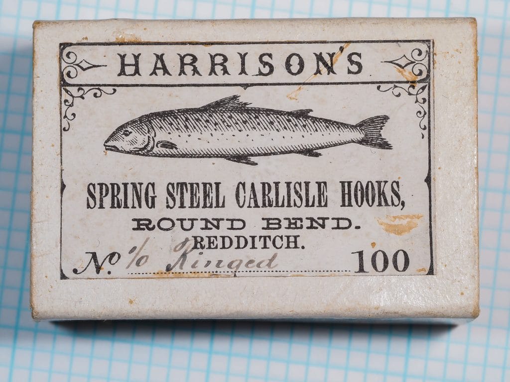 Harrisons Spring Steel Carlisle Hooks — original box front panel showing letterpress printing and salmon illustration — 100-count 1/0 size — blued spring steel hooks