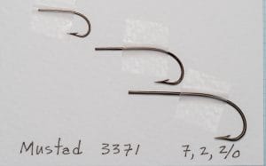 Mustad 3371 — three hooks at different sizes (7, 2, 2/0) showing size scaling across the range — bronzed finish — grid reference