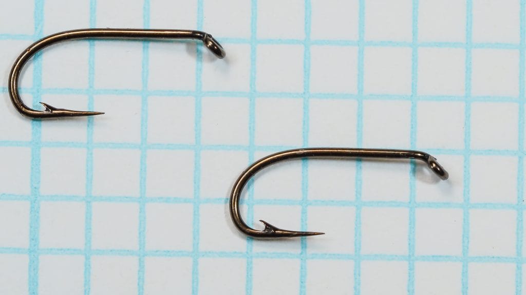 Two bronzed Allcocks W210 sproat hooks displayed side by side on grid background