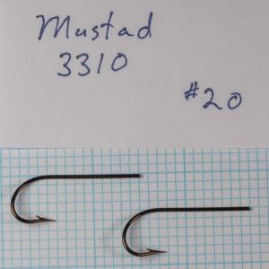 Two Mustad 3310 hooks identified as size 20 beside a handwritten specimen card on a measurement grid.