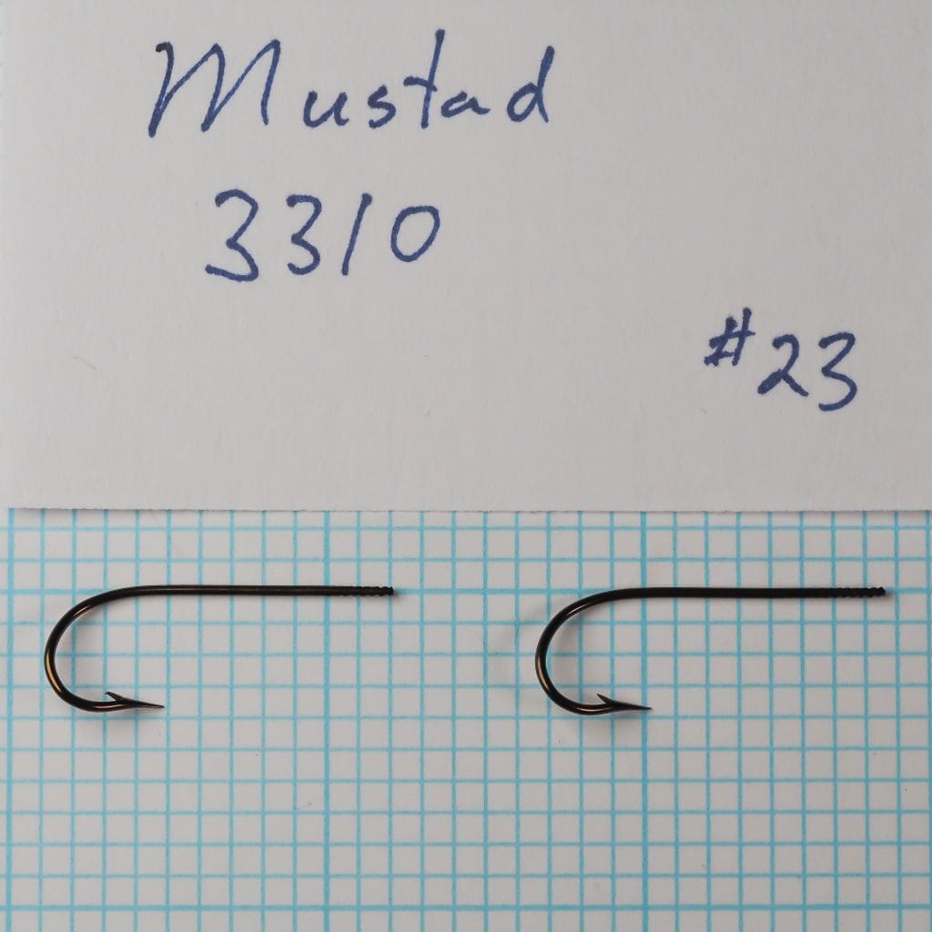 Two Mustad 3310 hooks identified as size 18 beside a handwritten specimen card on a measurement grid.