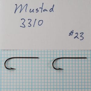 Two Mustad 3310 hooks identified as size 18 beside a handwritten specimen card on a measurement grid.