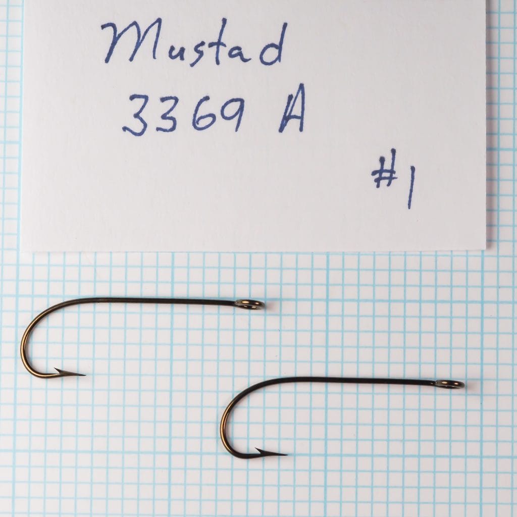 Two Mustad 3369 A No. 1 hooks on a measurement grid with handwritten identification card.