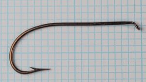 Mustad 3391 Sproat hook in flat profile against graph grid, straight eye alignment visible.