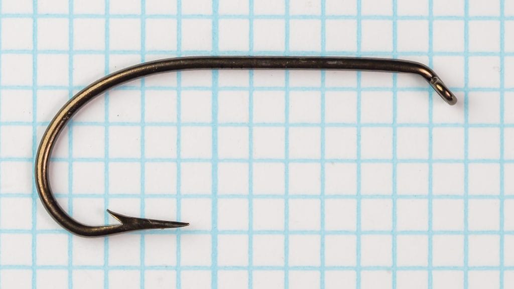 Mustad 3391 Hook C — full overhead view on grid — shows hook profile from eye down to point — bronzed finish detail