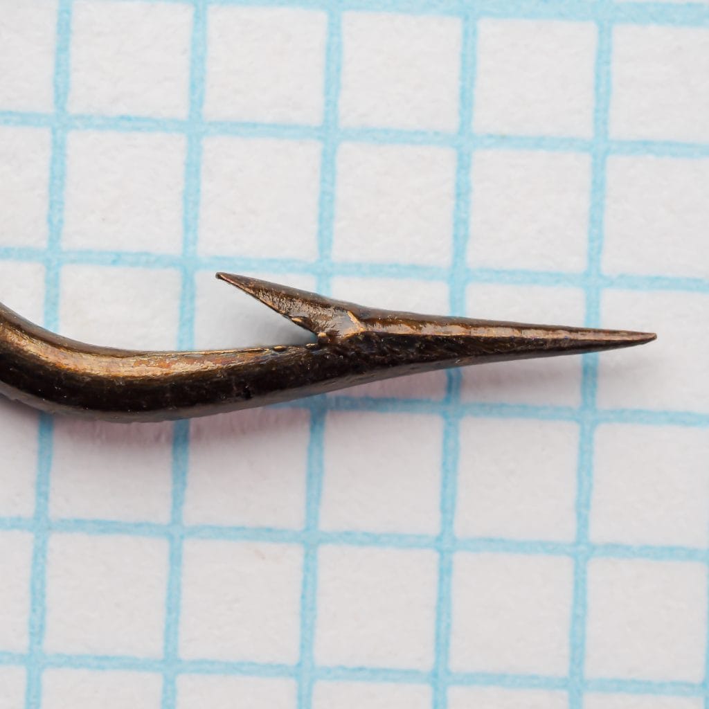 Mustad 3391 Hook Point macro — extreme close-up of point tip and barb geometry — shows fine grinding and superior-point inner taper