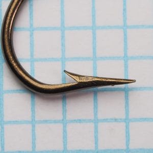 Mustad 3391 Sproat hook angled view showing point and barb, bronzed finish with surface patina.
