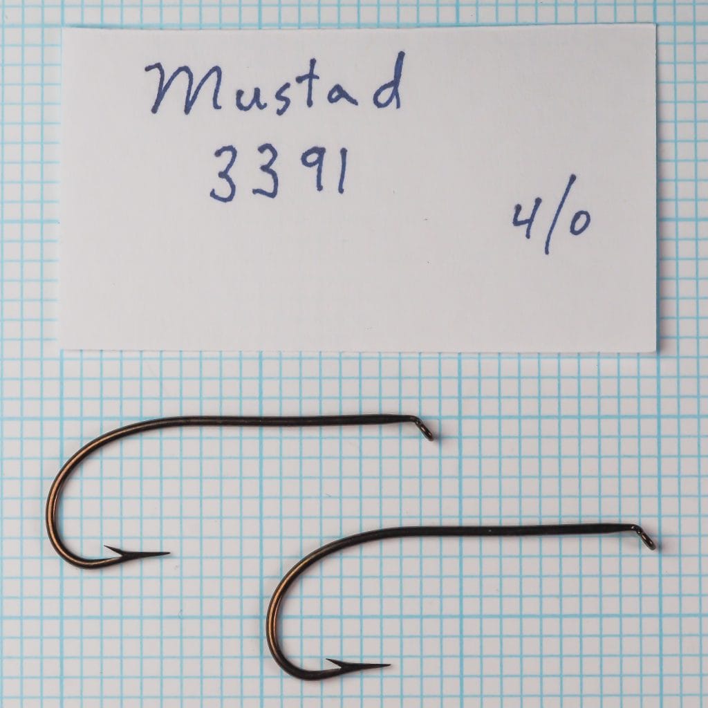 Mustad 3391 Hooks — two specimens side-by-side on grid — handwritten label showing model number and size 4/0