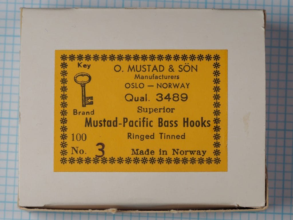 Mustad 3489 Pacific Bass Hooks — original cardboard box with golden-yellow label and Key Brand trademark — Size 3 — eight-line Mustad label format