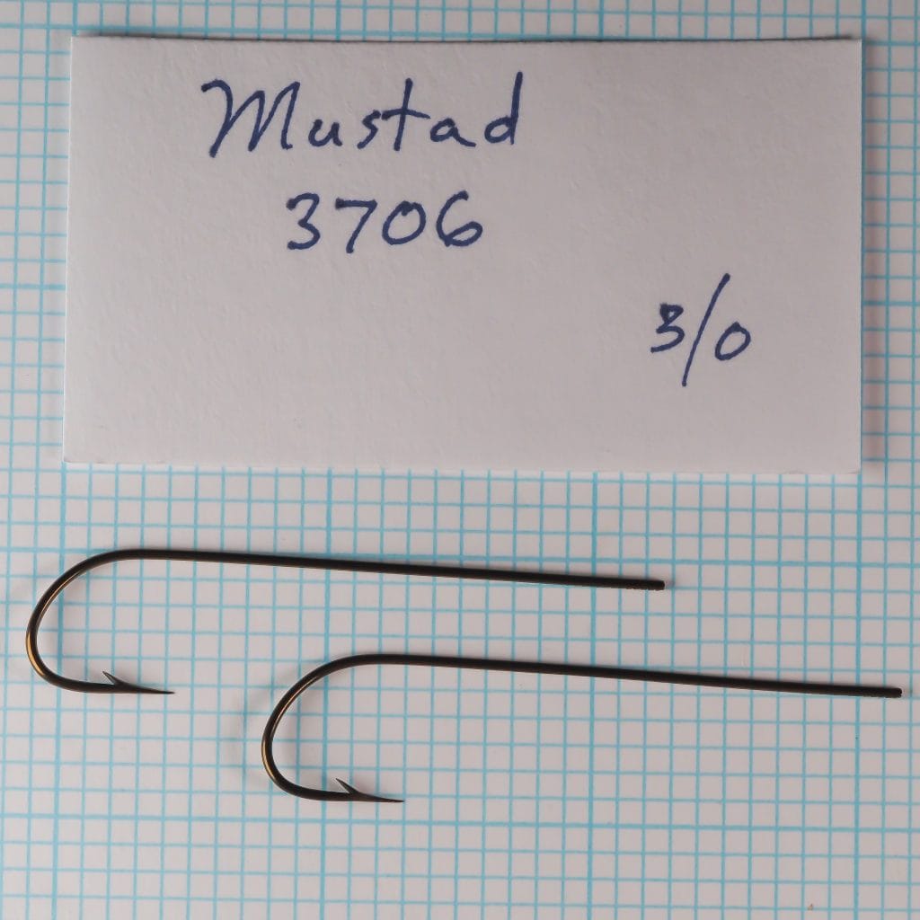 Two Mustad 3706 hooks identified by a handwritten card as size 3/0.