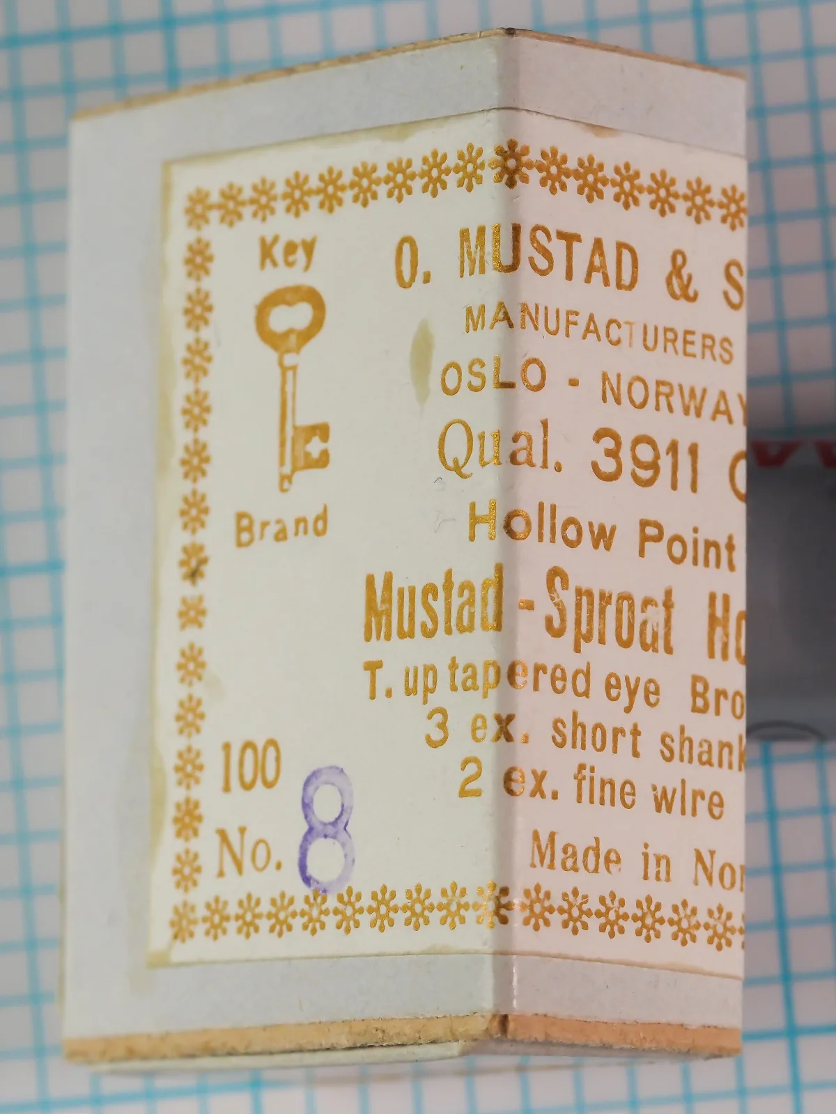 Mustad 3911 C sales card and packaging — front label showing Key Brand logo, manufacturer name, and specifications — size 8 — gold foil lettering on cream cardstock