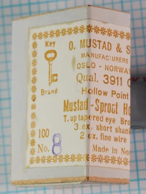 Mustad 3911 C sales card and packaging — front label showing Key Brand logo, manufacturer name, and specifications — size 8 — gold foil lettering on cream cardstock