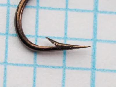 Mustad 3911 C hook — profile view showing the point, barb, and bend geometry — bronzed finish — size 8 — demonstrates hollow-point taper