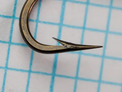 Mustad 7957 E — close-up of hook point showing hollow-point geometry and reversed offset — size No. 7 — bronzed finish