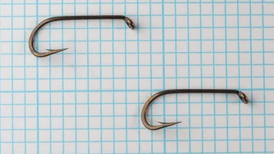 Mustad 7957 E — two hooks showing full side profile and bend geometry — size No. 7 — round bend with 2X-long shank