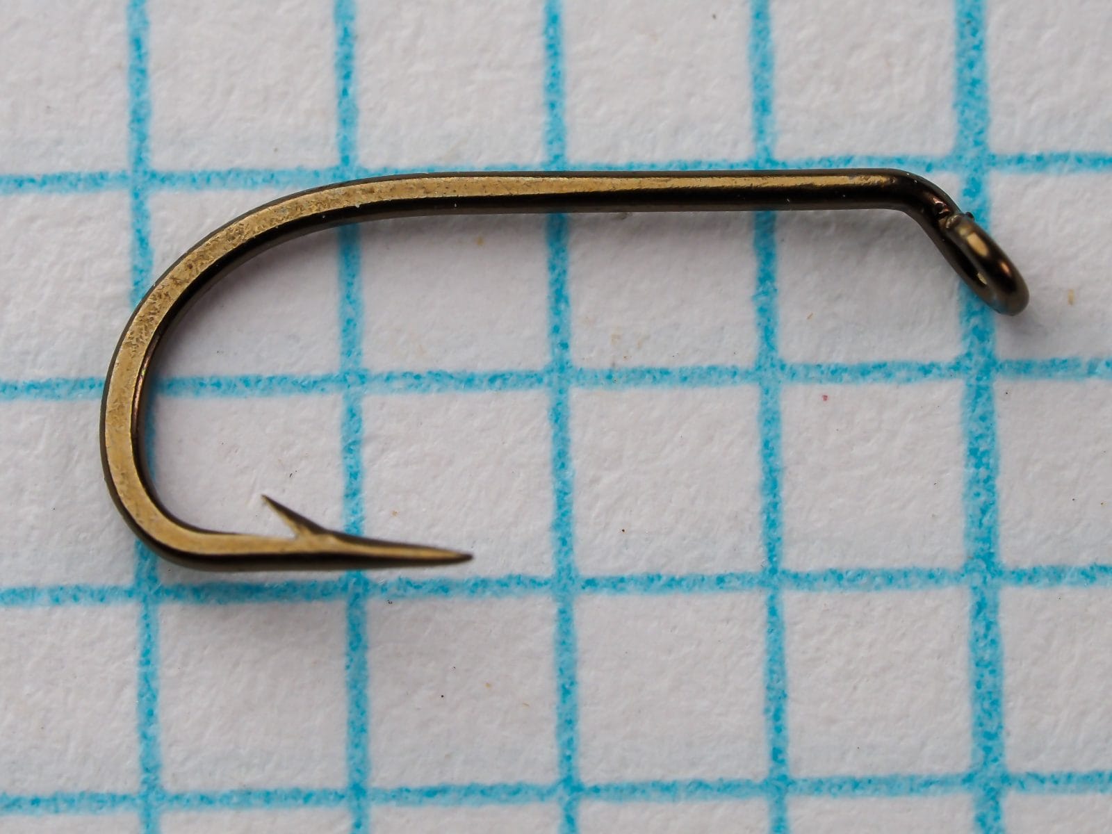 Mustad 56310 — full side profile showing Limerick bend geometry, ringed ball eye, and forged shank — bronzed finish — on measurement grid for scale