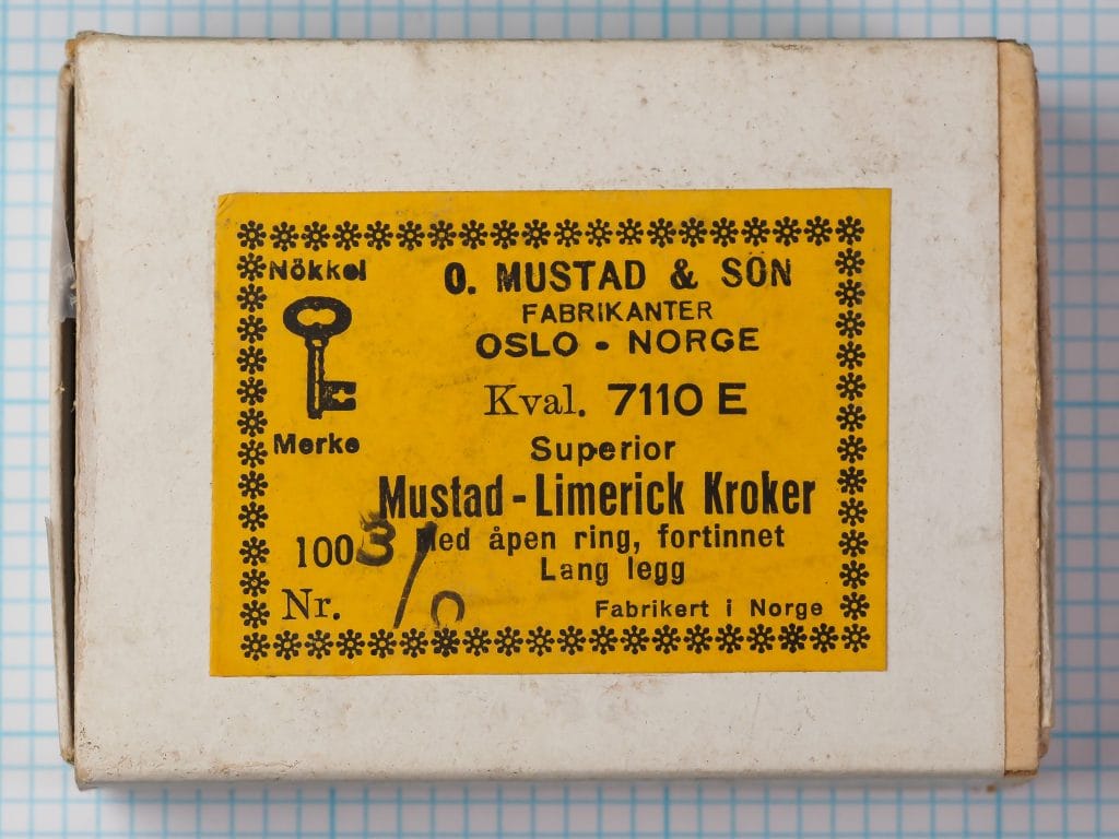 Mustad 7110 E — box label and packaging front — size 3/0 — yellow with snowflake border