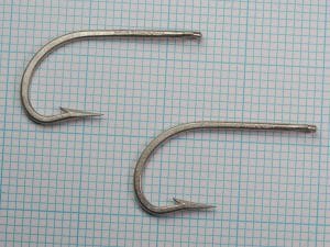 Mustad 7731 A Sea Demon — two hook specimens on measurement grid — showing size consistency and complete profile of the design