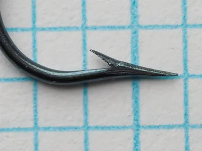 Mustad 7871 Bridgeport Aberdeen — side profile showing point geometry, superior point taper, marked shank ridges, and characteristic light blued finish, size No. 3, photographed on measurement grid