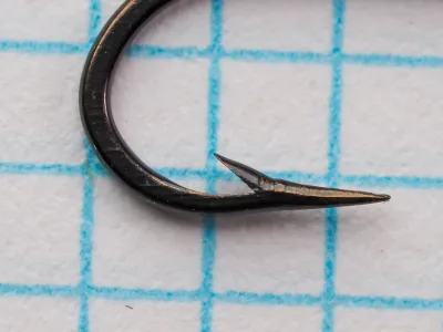 O. Mustad & Son Mustad 7947 B — side profile of hook point showing hollow-point concave geometry — size 12 — bronzed finish with copper toning