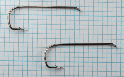Two Mustad 9856 size 2/0 hooks in side view on grid paper.