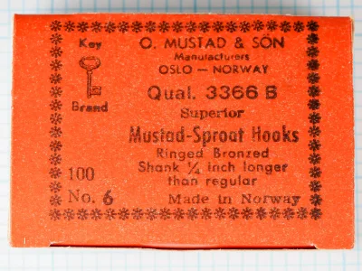 Mustad 3366 B Hook Box Label — original 1950s orange-red kraft paper with black letterpress printing, snowflake border, complete label text and Key Brand logo