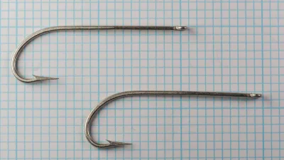 Mustad 3404 E size 3/0 — two hooks side-by-side showing consistency — full profile on measurement grid
