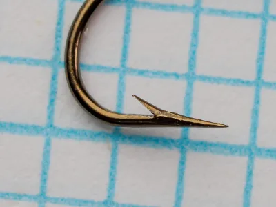 Mustad 38933 hook point detail — close-up side view — size 8 — hollow point geometry with concave inner face visible