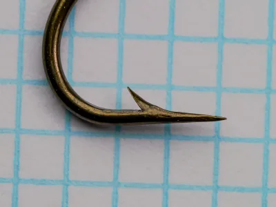 Mustad 3911 — side profile showing point geometry and hollow concave inner face — size No. 4 — bronzed finish