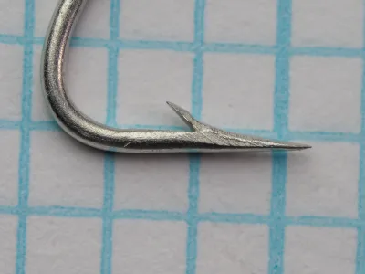 Mustad 8210 — side profile of hook point showing concave hollow point geometry — size No. 5 — tinned finish