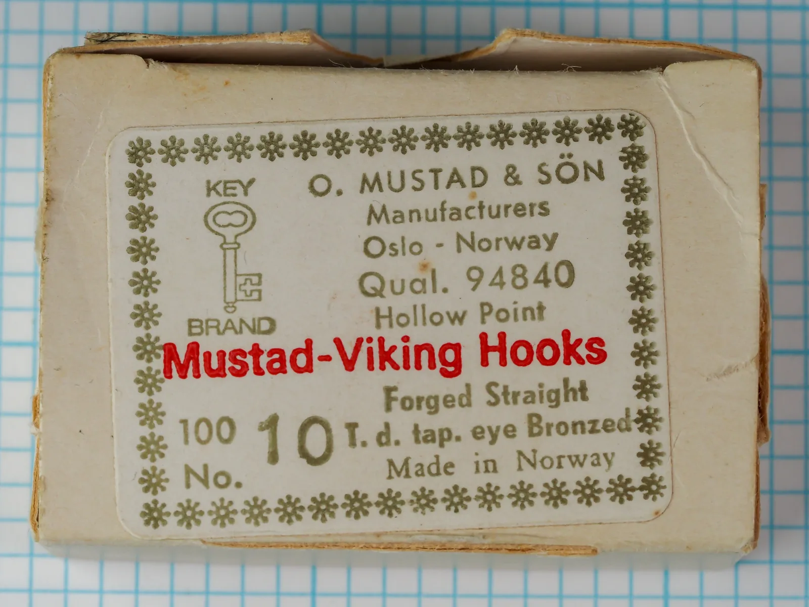 Mustad 94840 — cardstock package label with eight-line typography, Key Brand logo, ornamental border — size 10 — bronzed finish, Oslo origin, c. 1950-1965