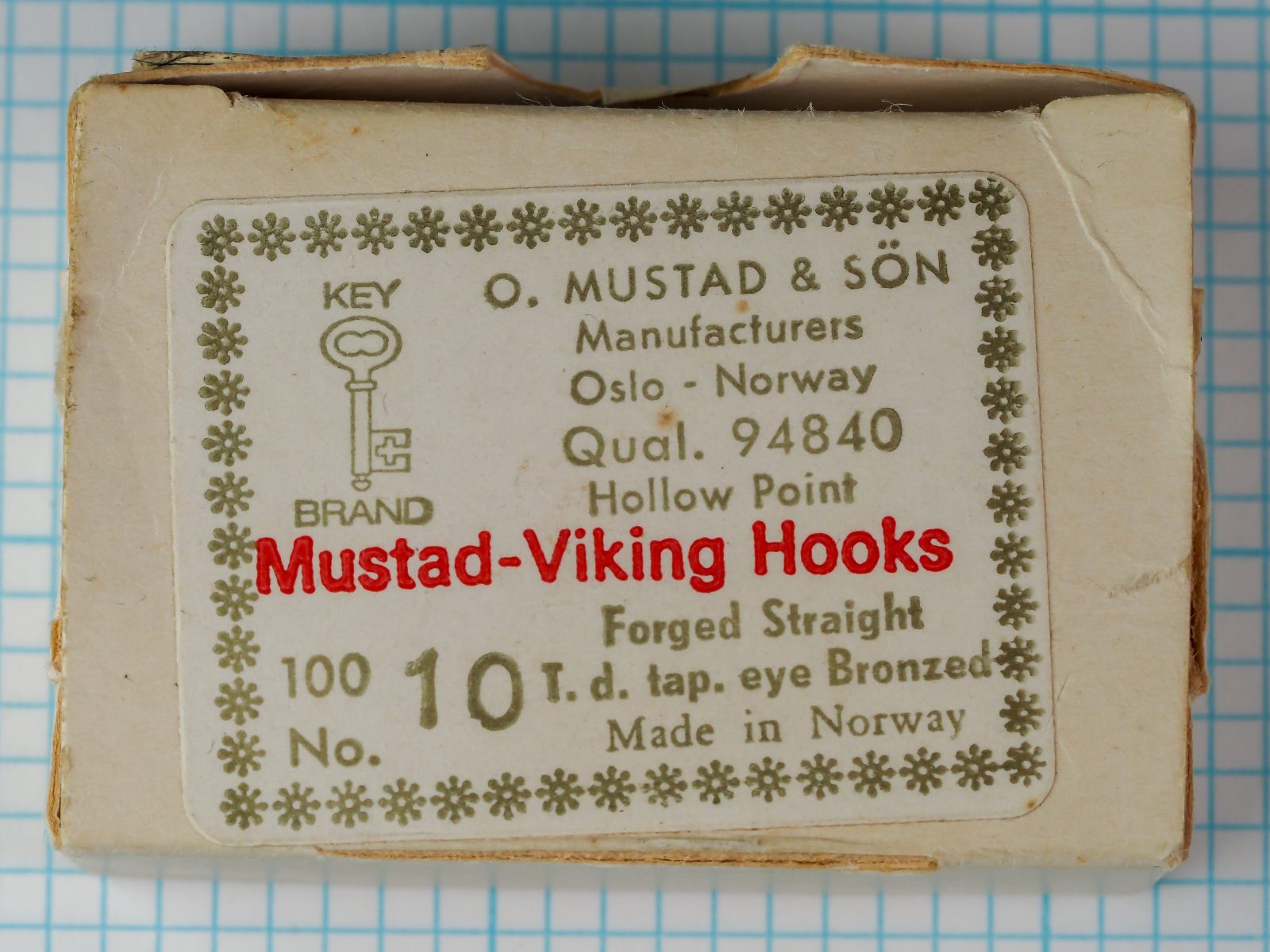 Mustad 94840 — cardstock package label with eight-line typography, Key Brand logo, ornamental border — size 10 — bronzed finish, Oslo origin, c. 1950-1965