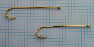 Pflueger 3320-G — two hooks side by side — size 2 — showing eye ring detail and bend consistency on measurement grid