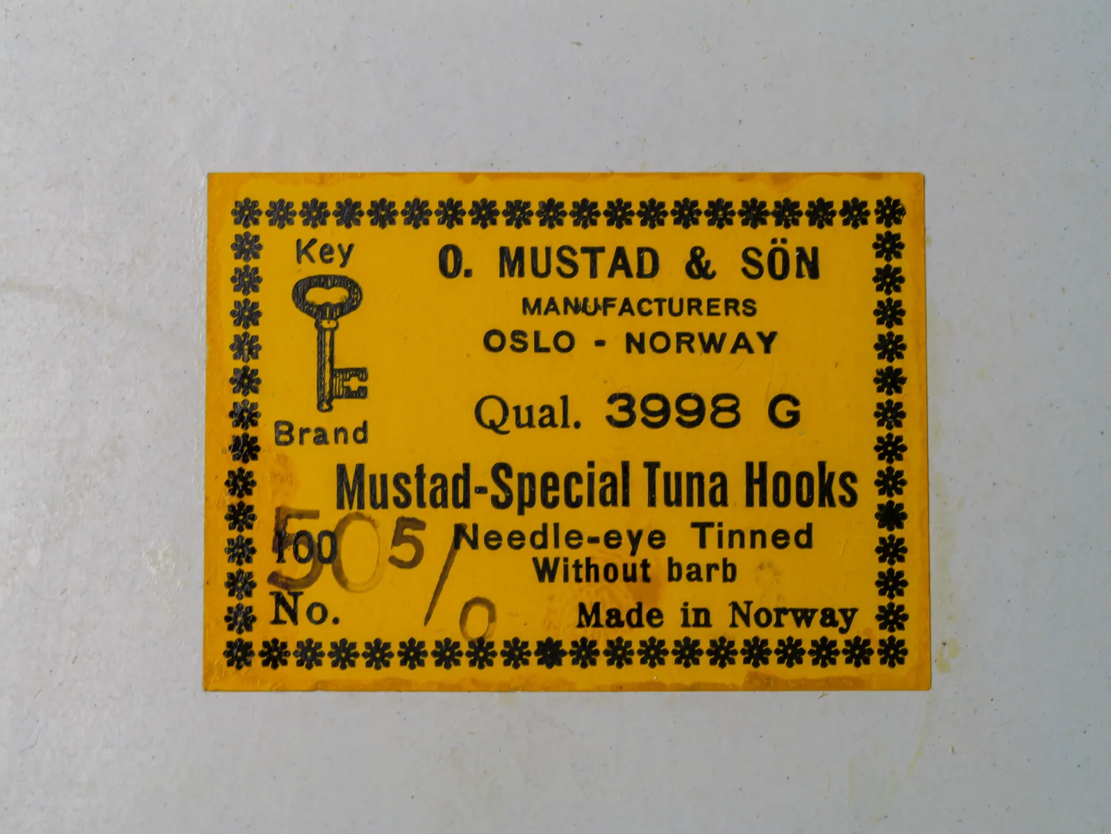Mustad 3998 G — original yellow cardstock sales label — size 5/0 — Key Brand trademark and Oslo Norway marking