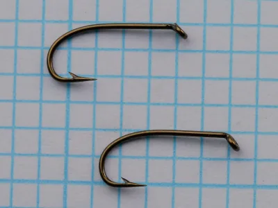 S. Allcock W 205 Sproat Hook — pair of size 12 specimens showing turned-down eye, sproat bend, and bronzed finish — on 1/10-inch measurement grid