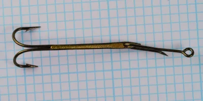 Mustad 3964 Sure Catch Hooks — overhead view of double-hook assembly showing both hooks and brazing junctions — Size 5 — on measurement grid background