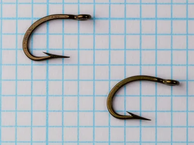 Mustad 9174 Hooks size 8 — two specimens showing consistency — side view profile with ringed eyes visible — bronzed finish — measurement grid background