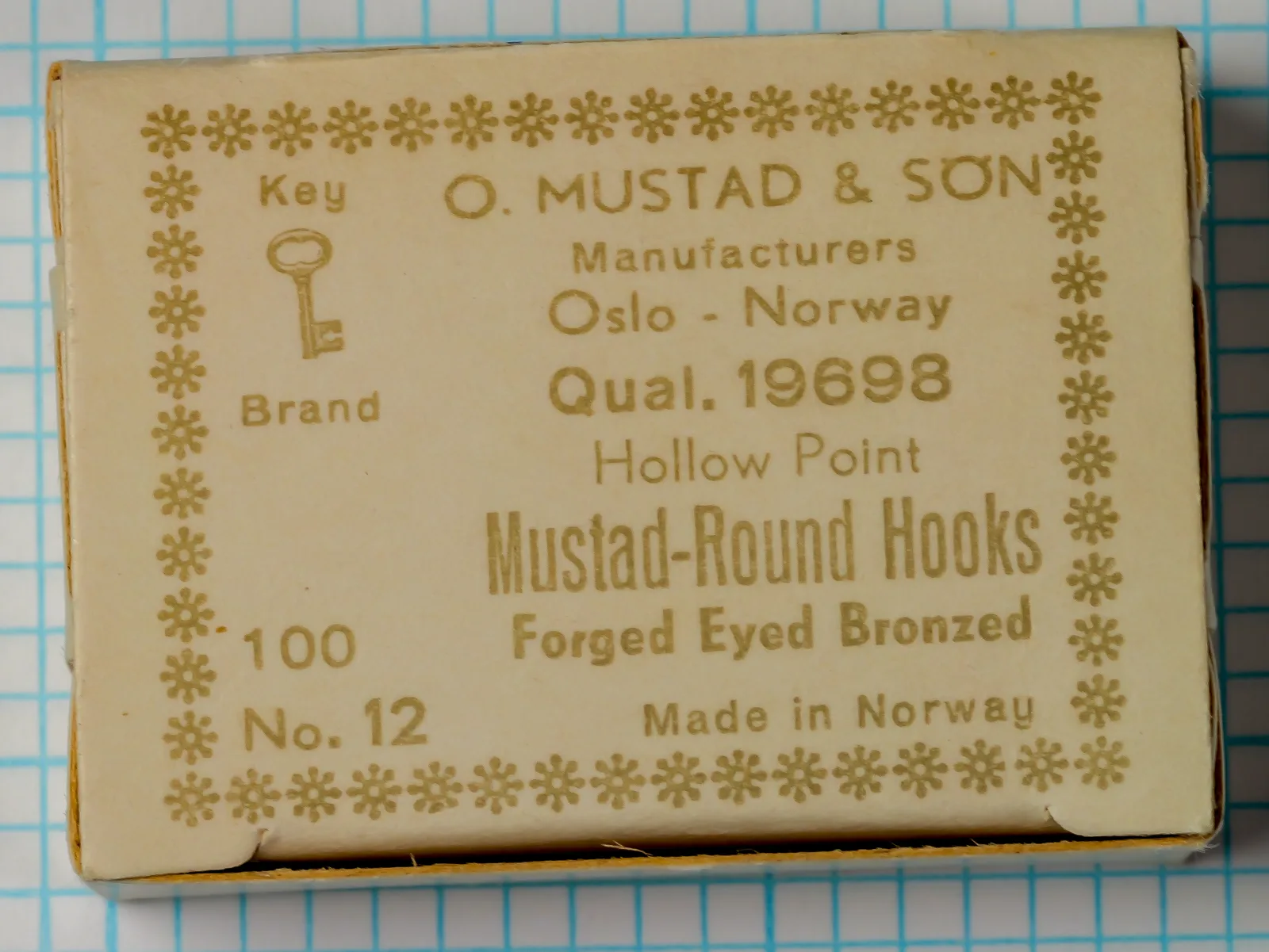 Mustad 19698 Key Brand Original Box — vintage packaging showing gold snowflake border design — size 12 — cream cardboard with letterpress printing