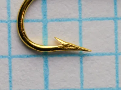 Mustad 3284 B Aberdeen — hook point detail on measurement grid — size 10 — gold plated finish