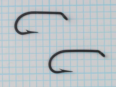 Mustad 3408 — two zinc-finish hooks — matte dark grey coating — showing variation in hook size and bend geometry consistency