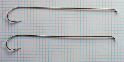 Two tinned Mustad 3576 L long-shank hooks displayed side-by-side at actual size