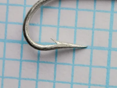 Mustad 3576D Bridgeport Snapper — close-up side profile of hook point and bend — Size 5 — showing snapper bend geometry and tinned finish texture