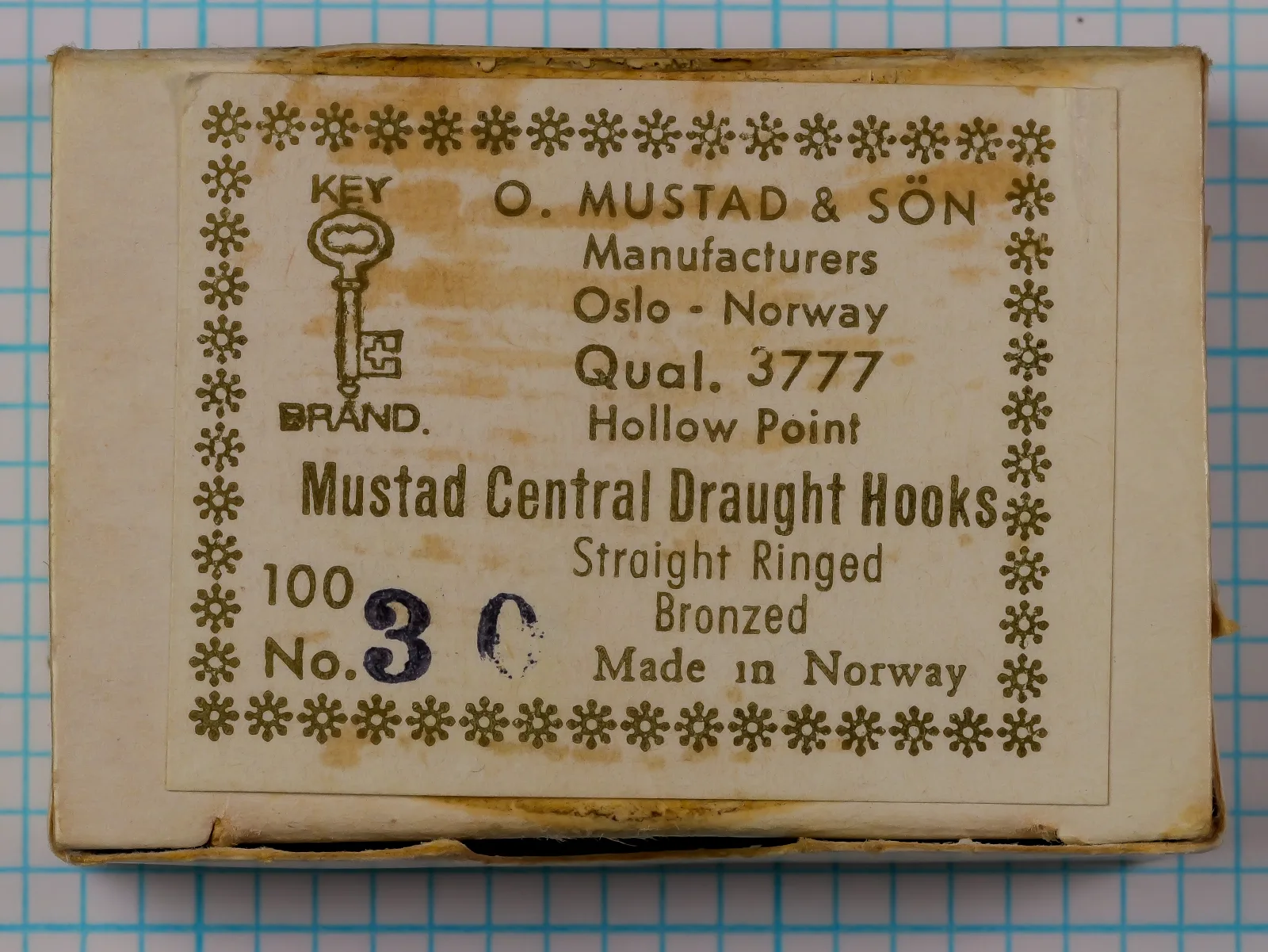Mustad 3777 Central Draught — original cardboard box with intact printed label and snowflake border — size 100 No. 3/0 — showing eight-line label format and Key Brand trademark