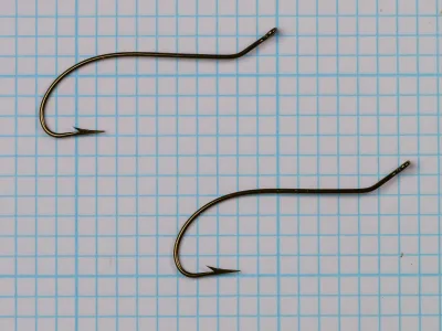 Mustad 3777 Central Draught — two hooks at different angles on measurement grid — size 3/0 — demonstrating kink geometry and consistency between specimens