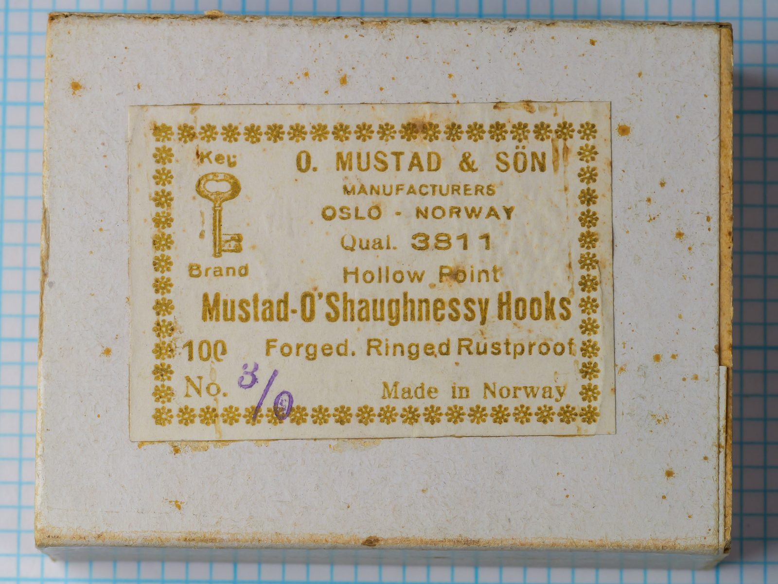 Mustad 3811 O'Shaughnessy Hook — vintage sales box with original label showing model code, point style, and manufacturing details — size 3/0 — golden-ink letterpress on cream cardstock with Key Brand logo