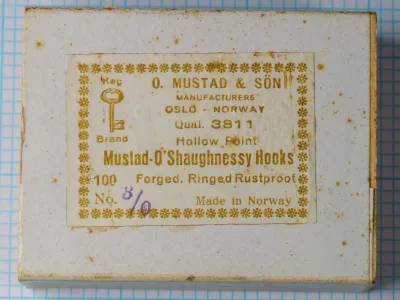 Mustad 3811 O'Shaughnessy Hook — vintage sales box with original label showing model code, point style, and manufacturing details — size 3/0 — golden-ink letterpress on cream cardstock with Key Brand logo