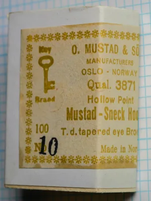 Mustad 3871 Size 10 — factory-sealed white paper box with gold foil-stamped label showing Key Brand logo, eight-line text block, and asterisk border motif