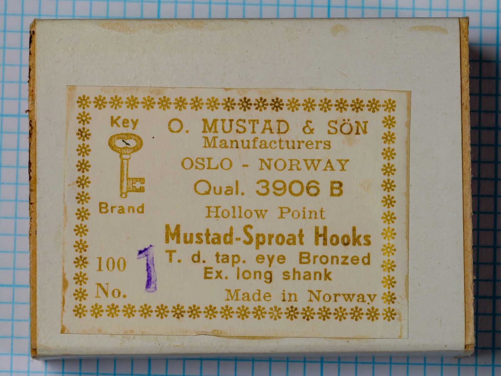 Mustad 3906B size No. 1 — vintage box label and packaging — showing eight-line label format with Key Brand logo, Oslo designation, quality code, and hook specifications — bronzed finish on grid background
