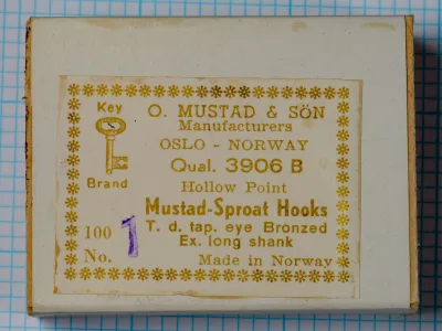 Mustad 3906B size No. 1 — vintage box label and packaging — showing eight-line label format with Key Brand logo, Oslo designation, quality code, and hook specifications — bronzed finish on grid background